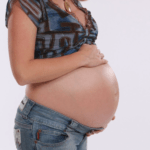 Beautiful woman's pregnant belly. Maternity photo by Enlightened Photography.